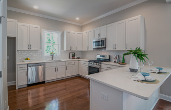 A modern modular kitchen, including custom cabinets, an integrated fridge pulls for flexibility, and top of the line storage solutions. The design capitalises on space by having designated areas for cooking, cleaning and storage. Top of the line countertops, built-in lighting and materials combine to create a kitchen that is both contemporary and visually pleasing while maintaining high functionality.